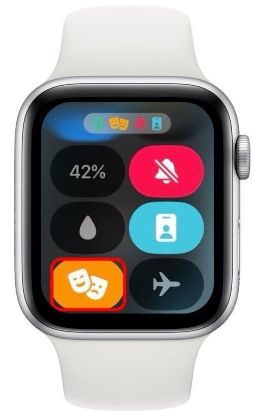 Centro di controllo dell'Apple Watch con l'icona della modalità teatro (icona arancione con due maschere teatro) cerchiata in rosso