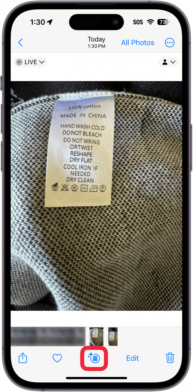 aplicação de fotografias para iphone mostrando uma fotografia de uma etiqueta de lavandaria numa camisola, com o botão de informação na aplicação de fotografias circulado a vermelho