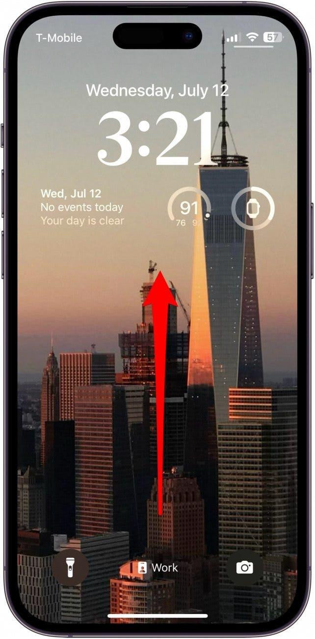 Écran de verrouillage de l'iPhone avec une flèche rouge pointant vers le haut depuis le centre de l'écran, indiquant qu'il faut glisser vers le haut depuis le centre de l'écran.