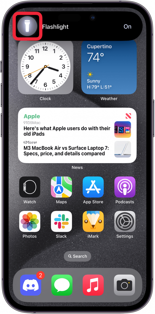 schermata iniziale dell'iPhone che mostra un'isola dinamica espansa con l'icona della torcia e un riquadro rosso intorno all'icona della torcia