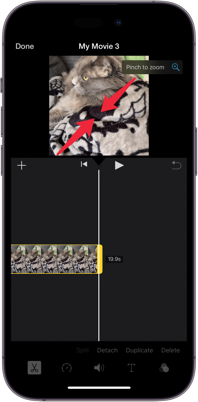 Екран за редактиране на приложението iphone imovie с червени стрелки, насочени навътре върху видеото, което показва, че потребителят трябва да натисне бутона за увеличаване на видеото